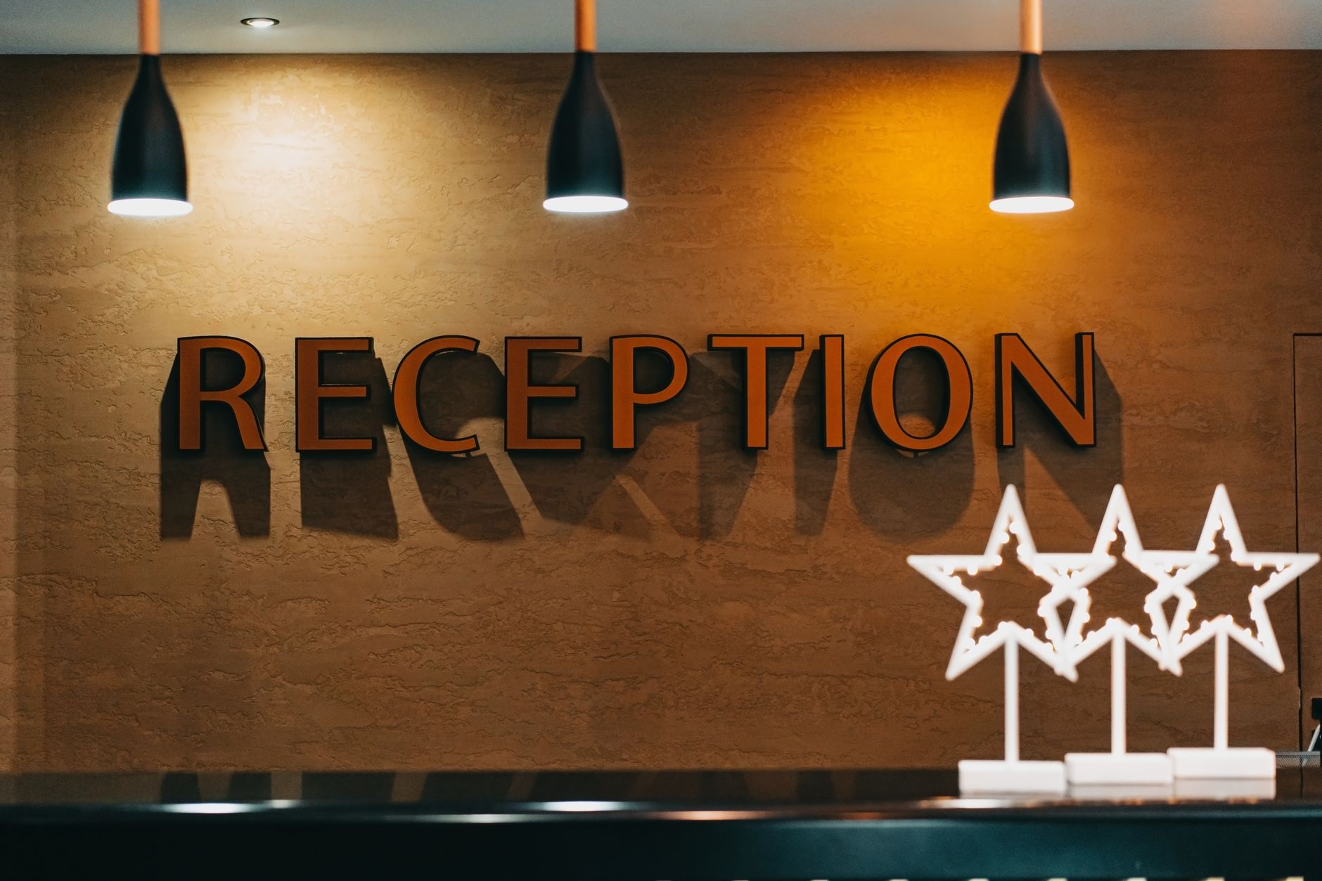 Recepção de hotel com letreiro e balcão iluminado